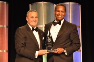 William H. Swanson (Chairman & CEO of Raytheon Company) hands the Black Engineer of the Year Award to John D. Harris, II, (Vice President, Contracts & Supply Chain - Raytheon Company)